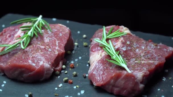 Raw steak with seasonings on a dark background — Stock Video