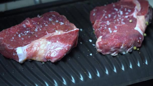 Nyers steak fűszerekkel a grillen — Stock videók