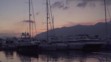 Yatların üzerinde gün batımı. Tivat limanında yatlar. Porto Karadağ
