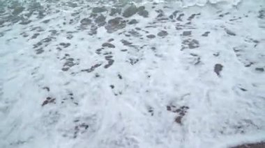 Deniz kumlu bir plaj üzerinde sörf