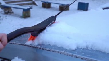 Yavaş çekim arabayı kardan temizliyor.