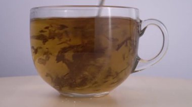 Çay demleniyor. Çayla şeffaf bir bardağın yakın görüntüsü.