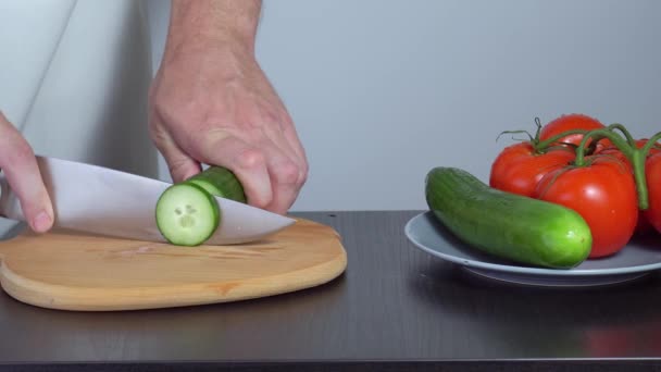 Vaření salátu. kuchař krájí okurky — Stock video
