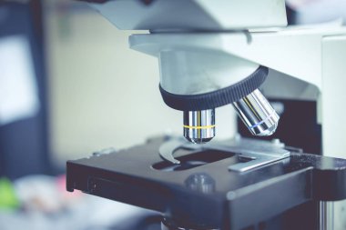 tablo üzerinde özel bir şey bulmak için bir bilim laboratuarı mikroskobu.