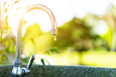 Temiz su musluk parlak sabah bahçede yeşil.