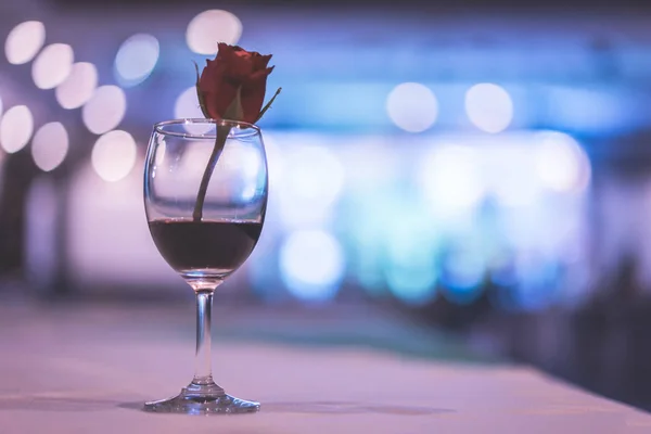 glass of expensive wine at a luxurious dinner withe red rose.
