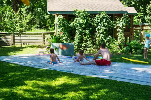 Vater Und Drei Kinder Spielen Auf Rutsche Garten — Stockfoto