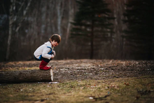 Мальчик Приседающий Бревне Готовится Прыгнуть — стоковое фото