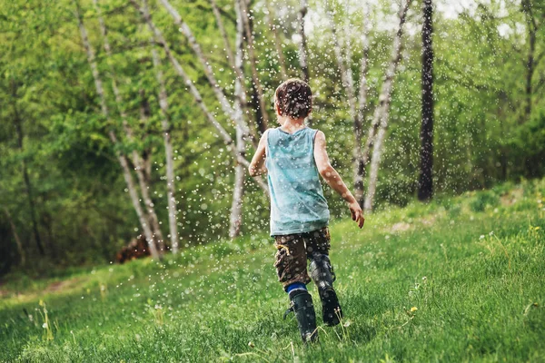 Chłopiec Biegnie Przez Zraszacz Ogrodzie — Zdjęcie stockowe