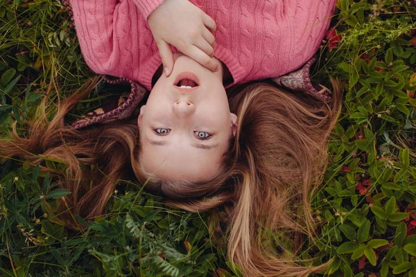 令人惊讶的女孩躺在草地上 头发散开了 — 图库照片