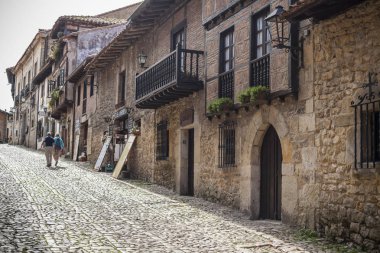 Typical street in touristic village of Santillana del Mar, province Santander, Cantabria, Spain. clipart