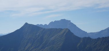 Sersemletici dağ manzarası yüksek tepeler ve yemyeşil yamaçlar sunuyor, güneş ışığıyla yıkanmış, sakin bir atmosfer yaratıyor açık hava meraklıları ve doğa severler için mükemmel.