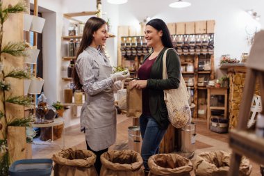 Müşteri ambalaj ücretsiz dükkanda yardım dükkâncı gülümseyen.