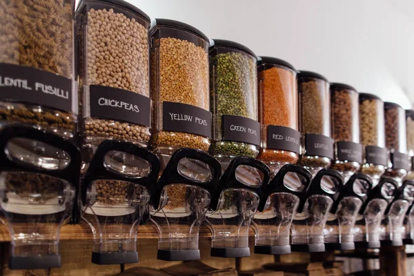 食料品店に表示される生の食品製品の側面図です 食品店インテリア エンドウ豆 オーガニック ショップで豆の完全食品容器が付いている棚 — ストック写真