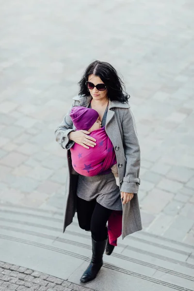 Draagdoek moeder draagt haar kind in geweven wrap. — Stockfoto