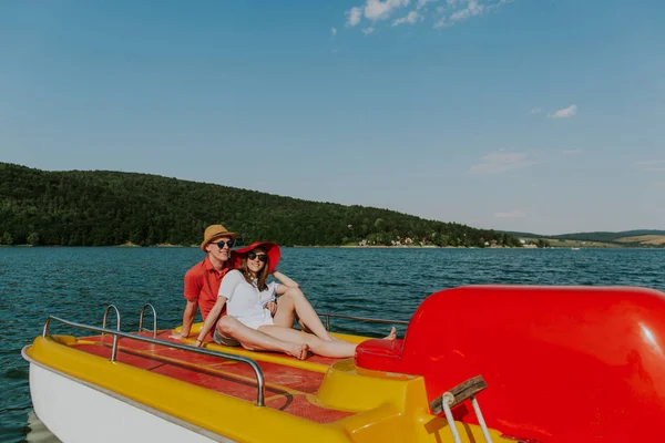 Веселые мужчина и женщина веселятся, катаясь на лодке по озеру . — стоковое фото