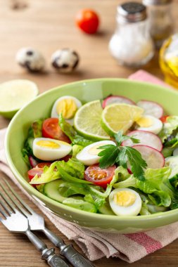 Taze salata sebze ve bıldırcın yumurtası rustik ahşap zemin üzerinde. Seçici odak.