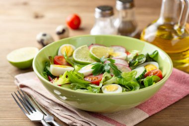 Taze salata sebze ve bıldırcın yumurtası rustik ahşap zemin üzerinde. Seçici odak.