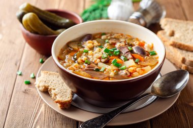 Geleneksel Rus çorbası Rassolnik salatalık turşusu ve pearl kapta tahta masada arpa. Seçici odak.