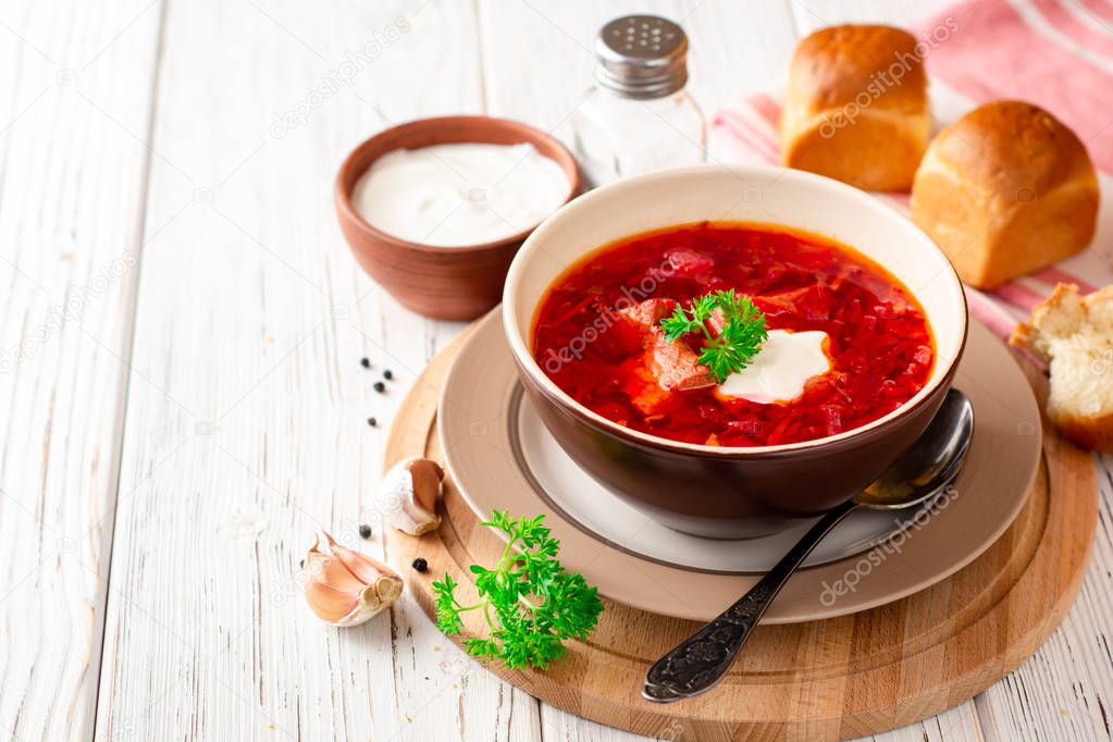 Borsch - traditional Ukrainian and Russian beetroot soup on white wooden background. Selective focus.