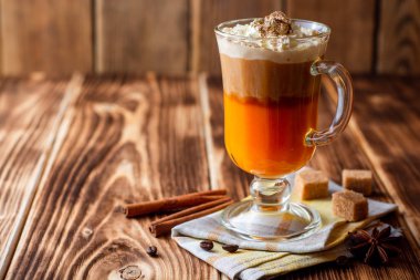 Krem şanti ve cam rustik ahşap zemin üzerine tarçın ile kabak spice latte. Seçici odak.