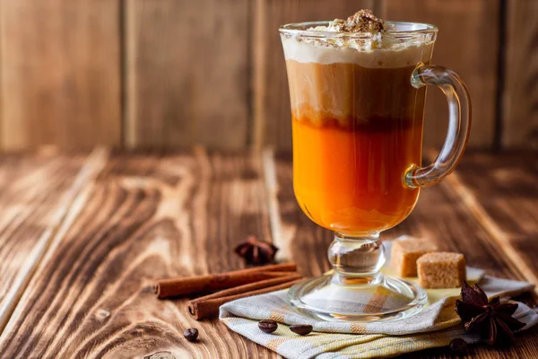 Krem şanti ve cam rustik ahşap zemin üzerine tarçın ile kabak spice latte. Seçici odak.