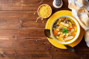 Mantar, sebze ve ahşap masa üzerinde bir kapta makarna Tavuk çorbası. Üstten görünüm. Kopya alanı.