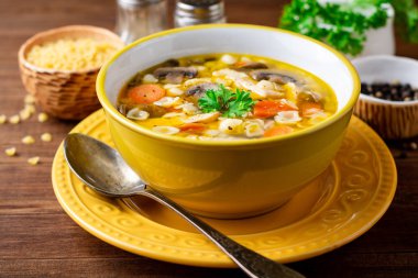 Mantar, sebze ve ahşap masa üzerinde bir kapta makarna Tavuk çorbası. Seçici odak.