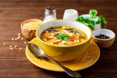 Mantar, sebze ve ahşap masa üzerinde bir kapta makarna Tavuk çorbası. Seçici odak.