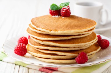 Ahududu ve beyaz ahşap zemin üzerine nane ile krep. Seçici odak.