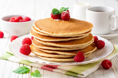 Ahududu ve beyaz ahşap zemin üzerine nane ile krep. Seçici odak.