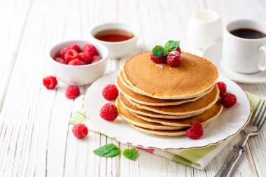 Ahududu ve beyaz ahşap zemin üzerine nane ile krep. Seçici odak.