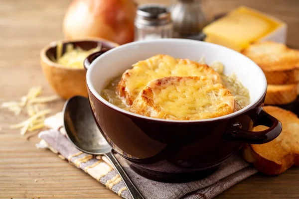 Fransız soğan çorbası ile kruton ve peynir rustik ahşap masa üzerinde. Seçici odak.
