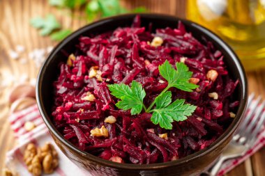 Pancar salatası wallnuts ve ahşap masa üzerinde bir kapta sarımsak. Seçici odak.