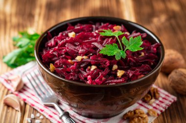 Pancar salatası wallnuts ve ahşap masa üzerinde bir kapta sarımsak. Seçici odak.
