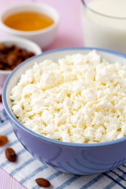 Mor ahşap zemin üzerine mavi kase süzme peynir. Seçici odak.