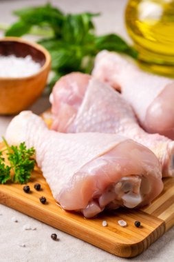 Baharatlar ve otlar kesme tahtası üzerinde çiğ tavuk budu. Seçici odak.