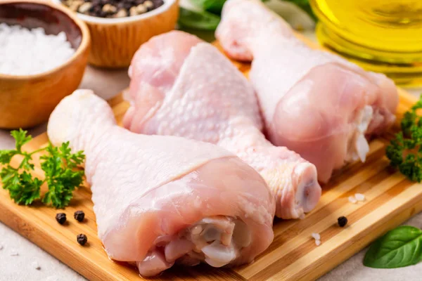 Baharatlar ve otlar kesme tahtası üzerinde çiğ tavuk budu. Seçici odak.