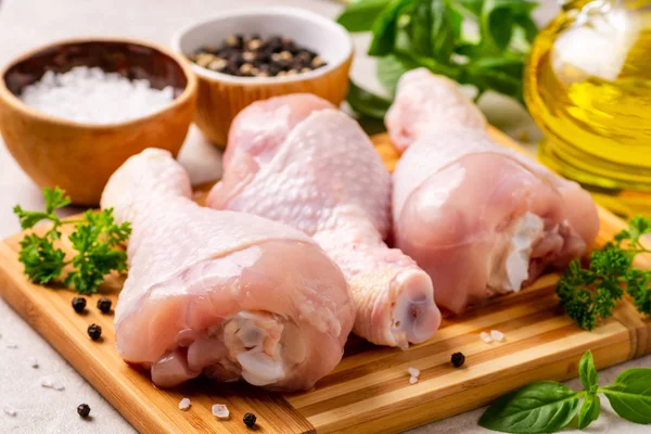 Baharatlar ve otlar kesme tahtası üzerinde çiğ tavuk budu. Seçici odak.