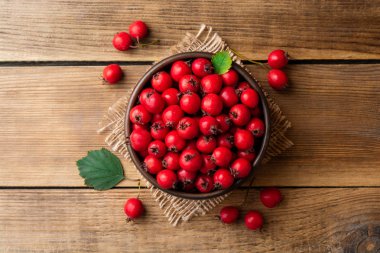 Rustik ahşap zemin üzerine seramik kase çilek Crataegus veya alıç. Üstten görünüm. Kopya alanı.