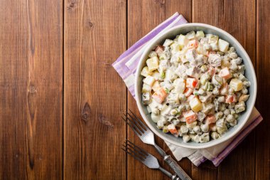 Geleneksel Rus salatası Olivier kase ahşap masa üzerinde. Üstten görünüm. Kopya alanı.