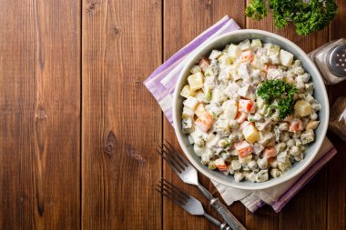 Geleneksel Rus salatası Olivier kase ahşap masa üzerinde. Üstten görünüm. Kopya alanı.