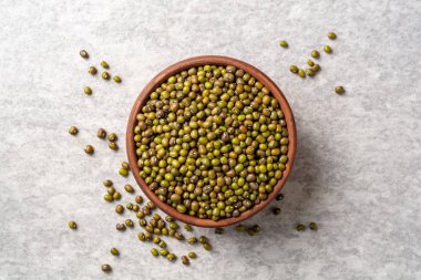 Seramik kase gri taş zemin üzerine yeşil mung fasulye. Üstten görünüm.