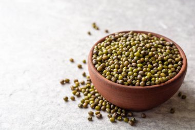 Seramik kase gri taş zemin üzerine yeşil mung fasulye. Seçici odak.