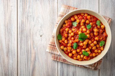 Baharatlı nohut Chana Masala ahşap masa üzerinde bir kapta köri. Geleneksel Hint yemeği. Üstten görünüm. Kopya alanı.