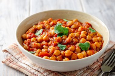 Baharatlı nohut Chana Masala ahşap masa üzerinde bir kapta köri. Geleneksel Hint yemeği. Seçici odak.