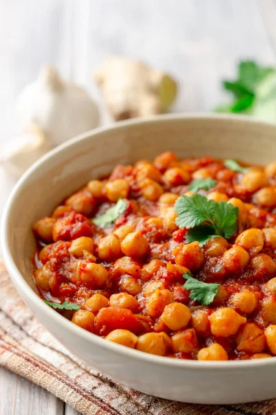 Baharatlı nohut Chana Masala ahşap masa üzerinde bir kapta köri. Geleneksel Hint yemeği. Seçici odak.
