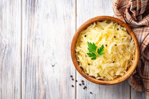 Rüstik arka planda ahşap kase içinde karabiber ve maydanoz ile ev yapımı lahana turşusu. Üst görünüm. Boşluk Kopyala.