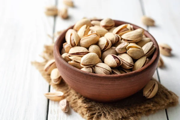 Nueces Pistacho Saladas Tazón Cerámica Sobre Fondo Madera Blanca Enfoque — Foto de Stock