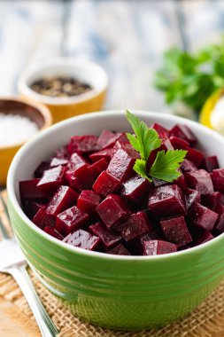 Rustik ahşap masa üzerinde kase maydanoz ile pancar salatası. Seçici odak.